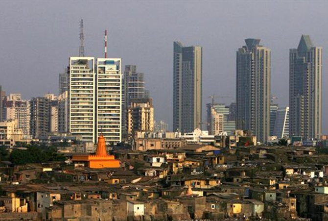 High rise buildings are seen behind a slum in Mumbai