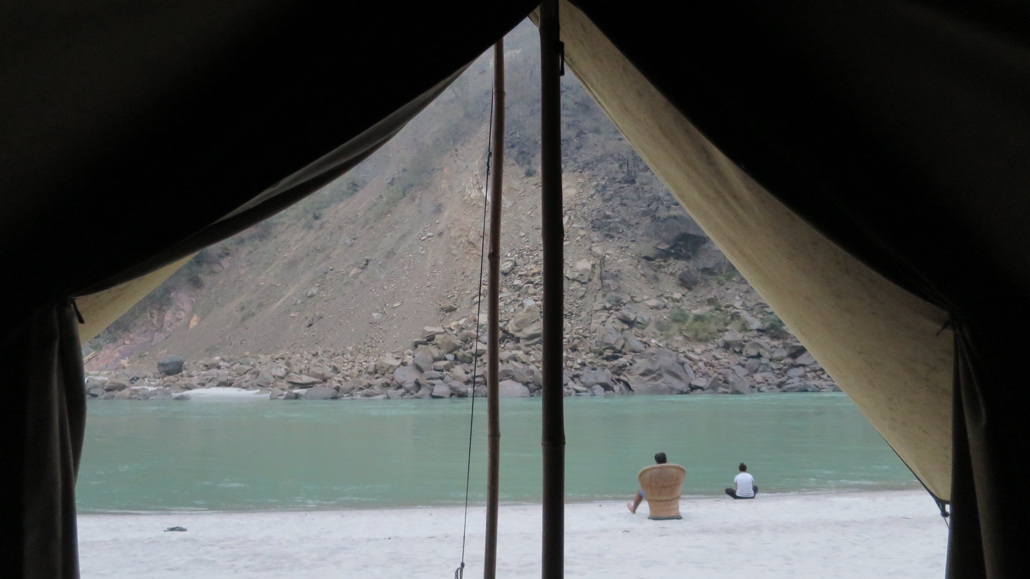 Blick direkt aus dem Zelt auf Fluss und Strand
